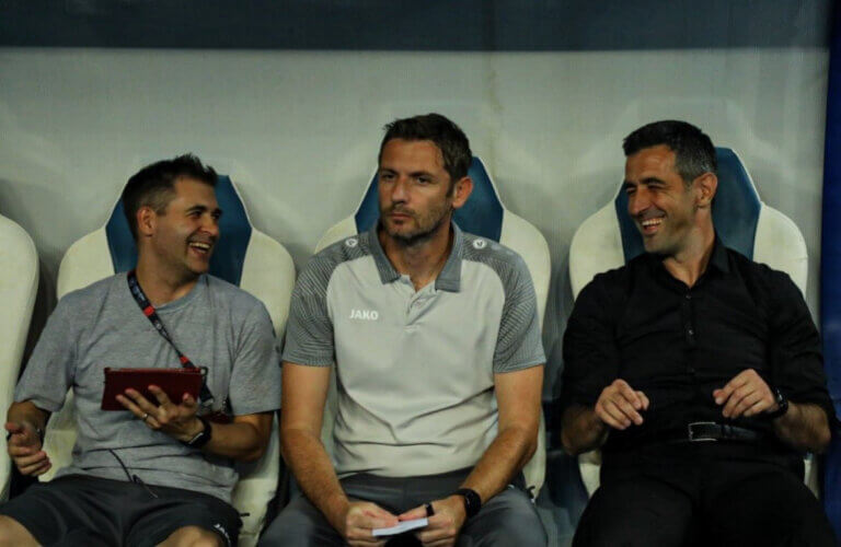 Gregg Britton (left) and Sogdiana Jizzakh manager Ivan Bošković (right) share a moment on the bench during an Uzbek Super League match in 2023.